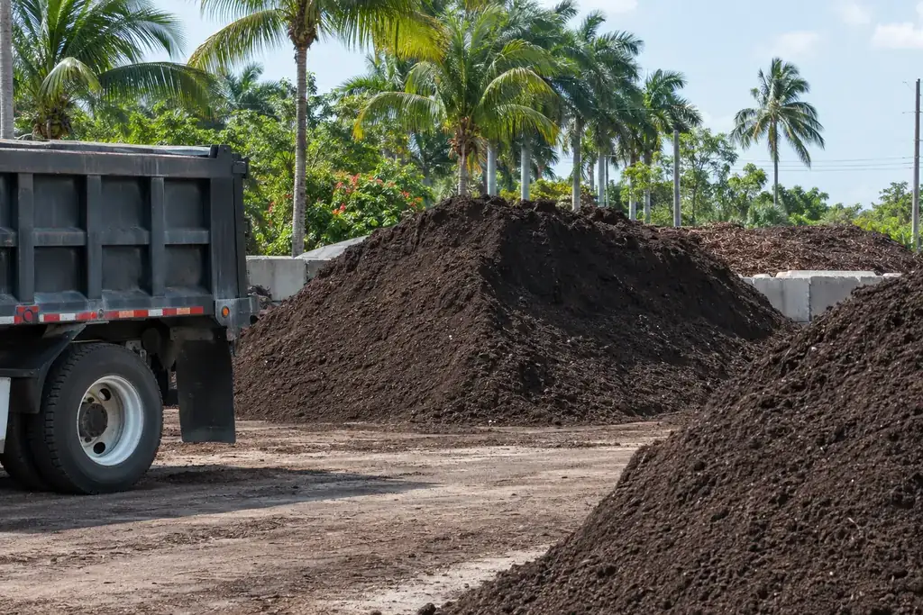 Bulk screened topsoil and planting mix piles with a dump truck