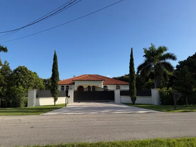 After: finished residential entrance with Italian cypress, palms and fresh lawn