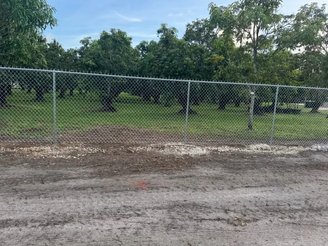 Graded, cleared strip along a chain-link fence line