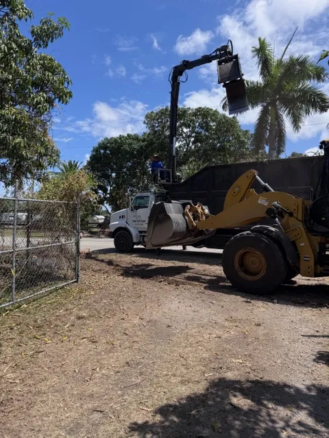 RGS CAT wheel loader feeding brush into a grapple truck