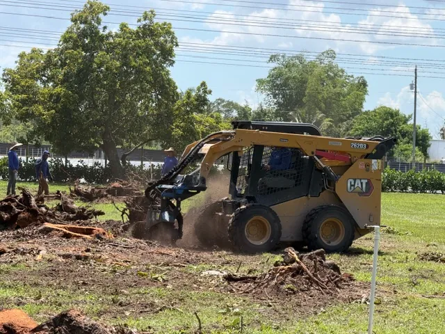 RGS crew using a CAT skid steer to pull stumps and roots